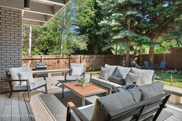 a view of a patio with couches table and chairs and potted plants