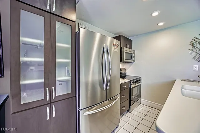 a kitchen with a sink a counter top space and living room view