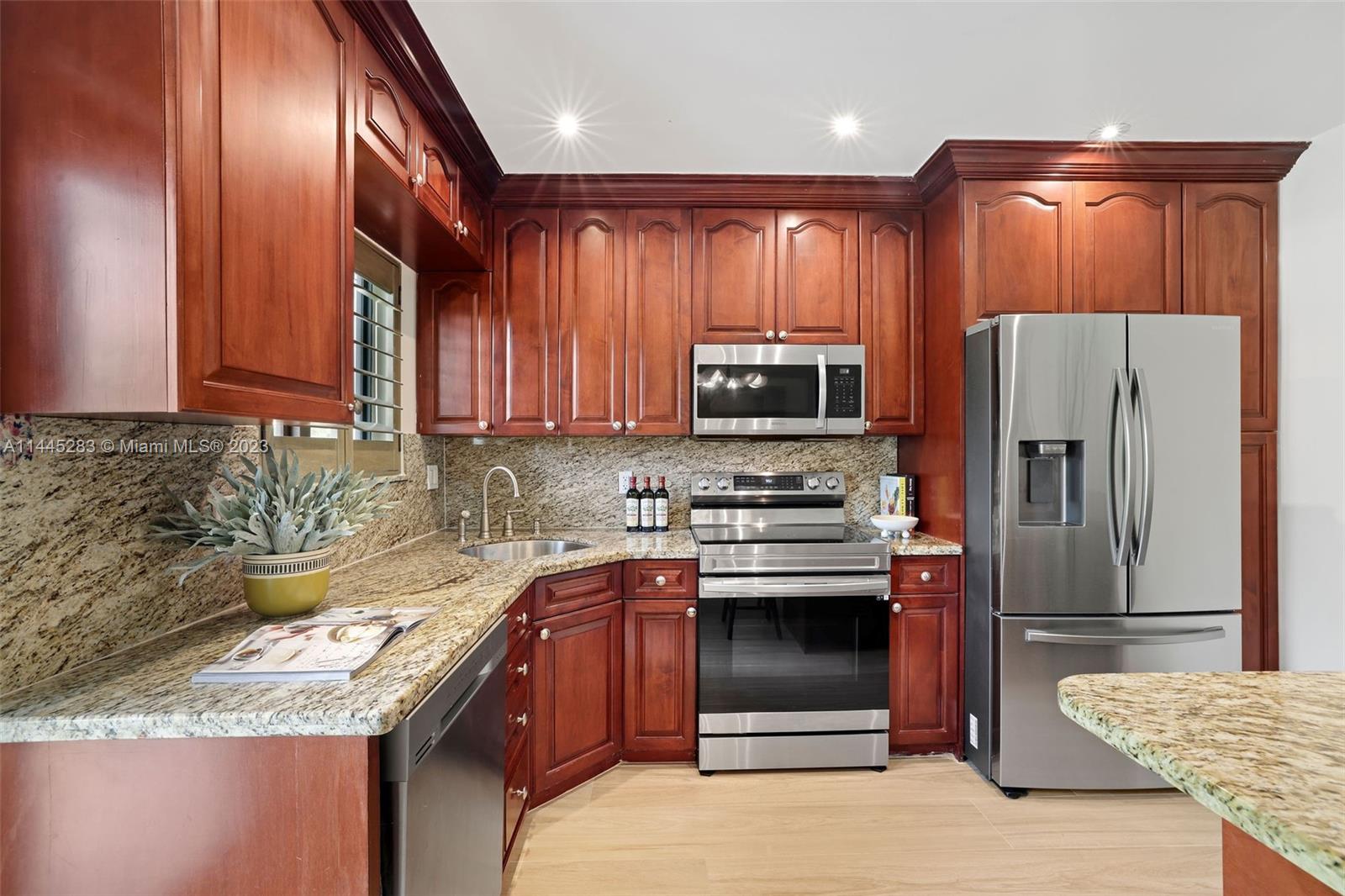 3411 Riviera Drive Coral Gables, FL 33134 - Photo 19 of 38 a kitchen with stainless steel appliances granite countertop a stove top oven a sink and dishwasher