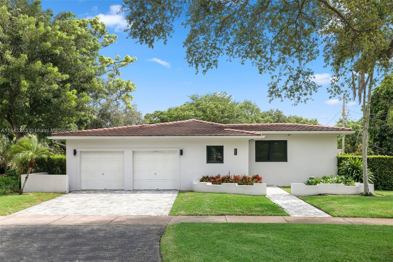 3411 Riviera Drive Coral Gables, FL 33134 - Photo 2 of 38 a front view of house with yard and outdoor seating