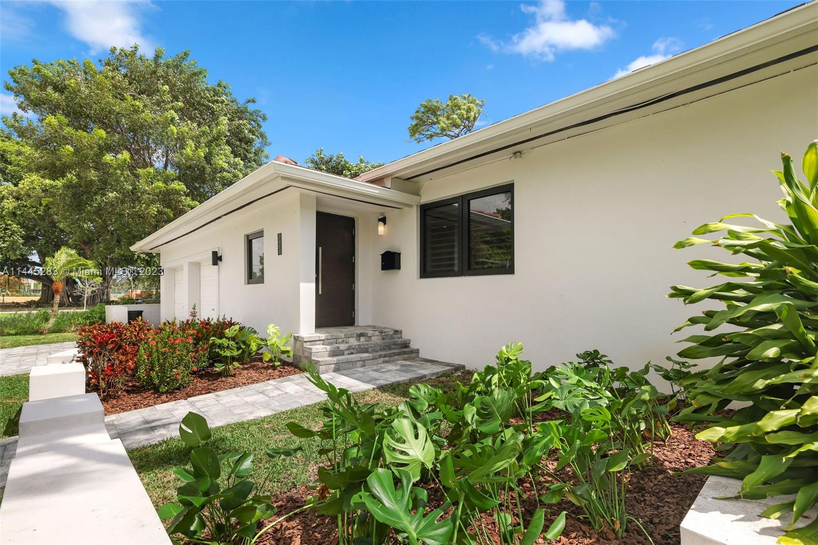 3411 Riviera Drive Coral Gables, FL 33134 - Photo 3 of 38 a front view of a house with plants