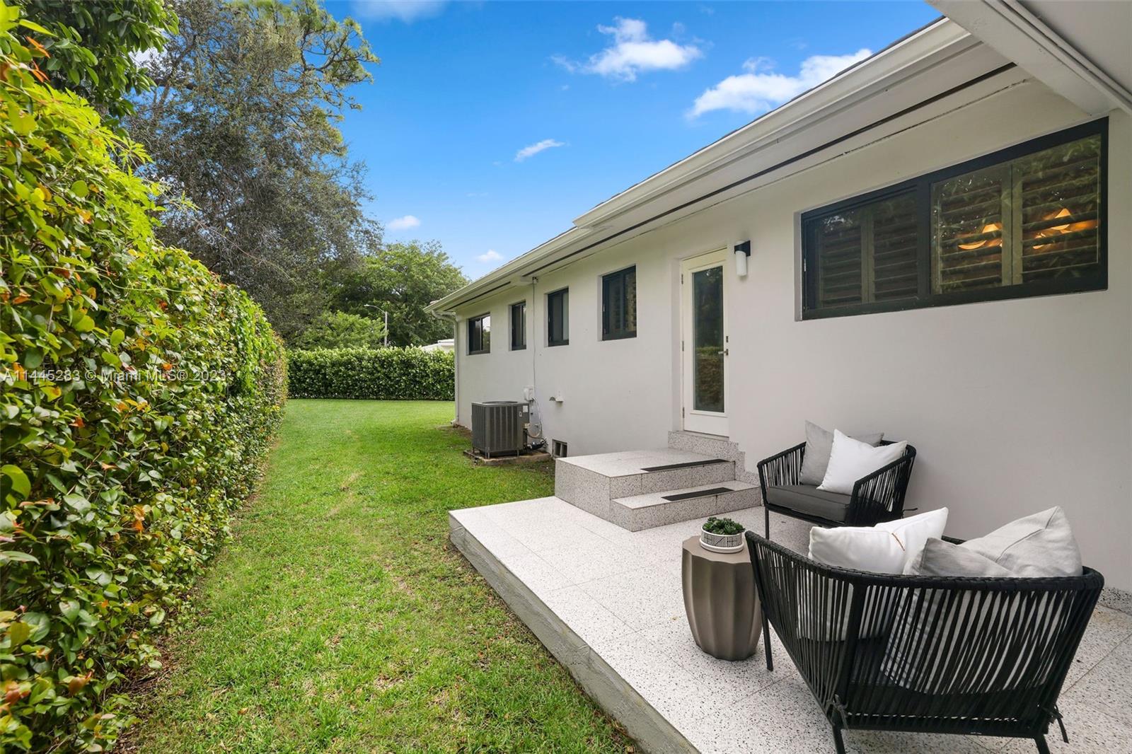 3411 Riviera Drive Coral Gables, FL 33134 - Photo 31 of 38 a view of a patio with couches chairs potted plants and a tree