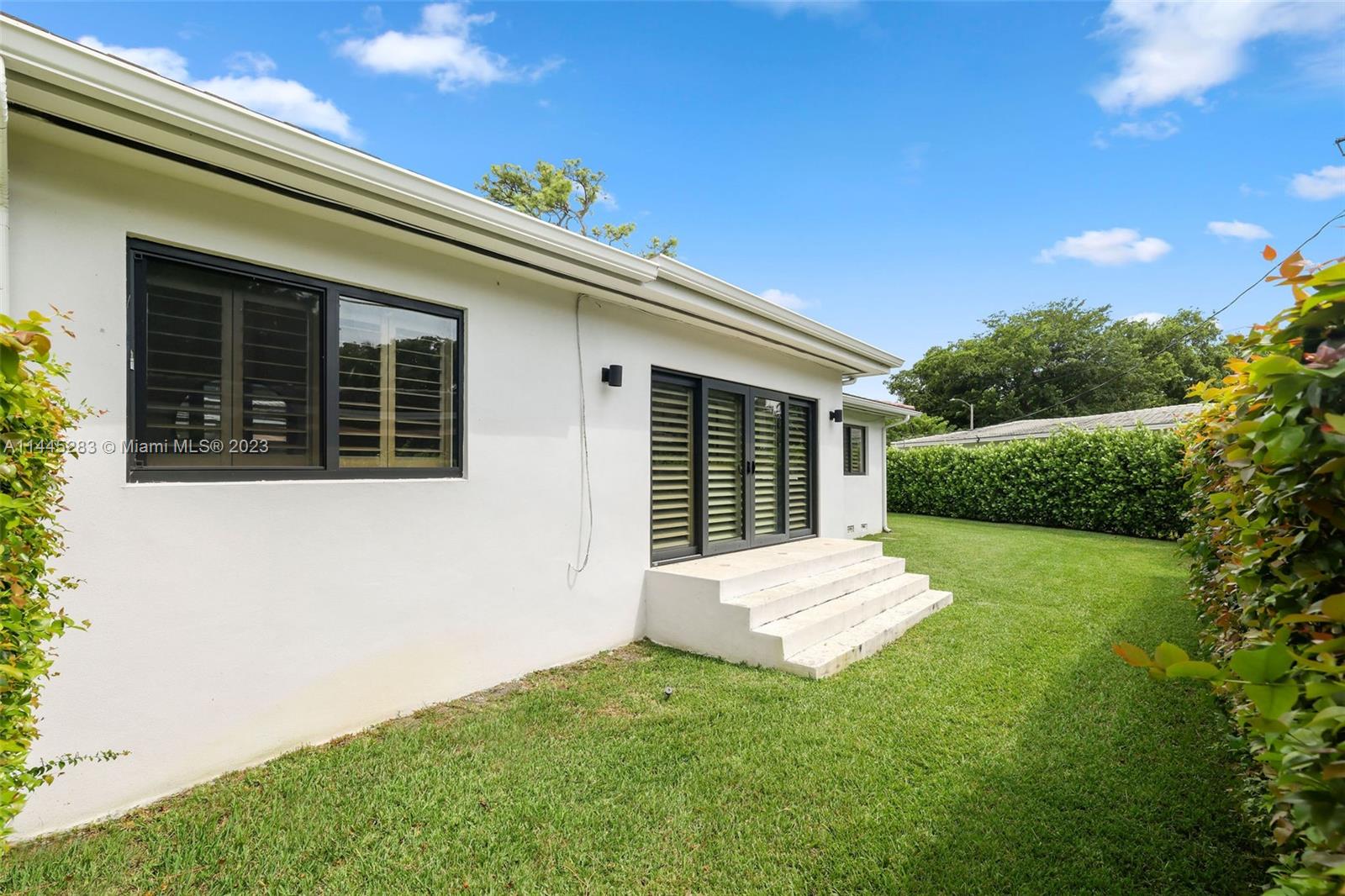 3411 Riviera Drive Coral Gables, FL 33134 - Photo 35 of 38 a backyard of a house with large trees and plants
