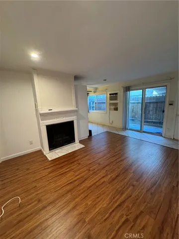 an empty room with wooden floor and fireplace