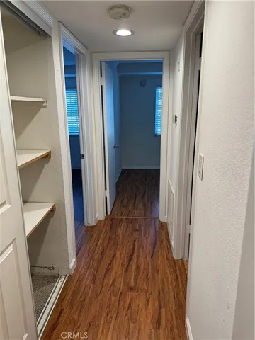 a view of a hallway with wooden floor and staircase