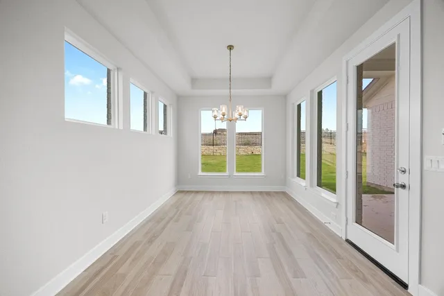 a view of an empty room with glass door and wooden floor