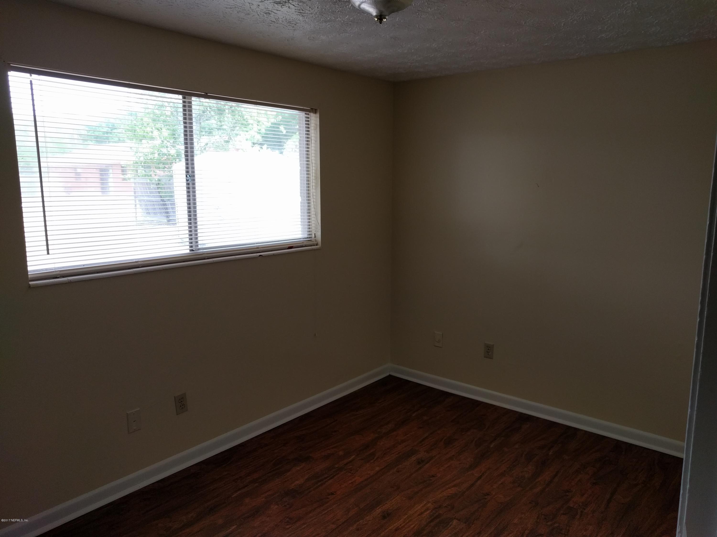 4339 Flintshire Road Jacksonville, FL 32208 - Photo 12 of 15 an empty room with wooden floor and windows