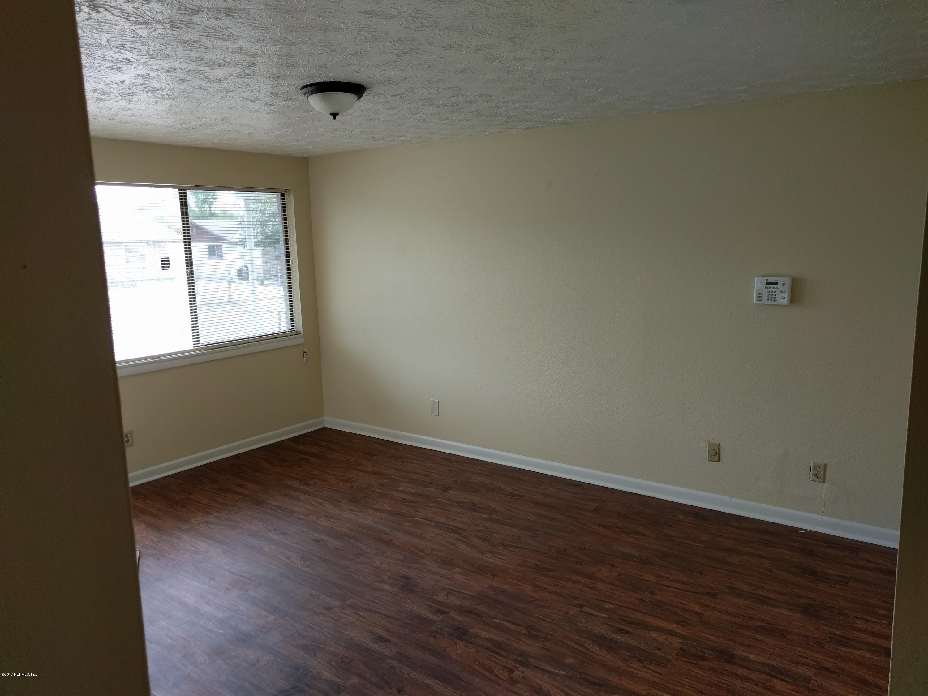 4339 Flintshire Road Jacksonville, FL 32208 - Photo 6 of 15 an empty room with wooden floor and windows