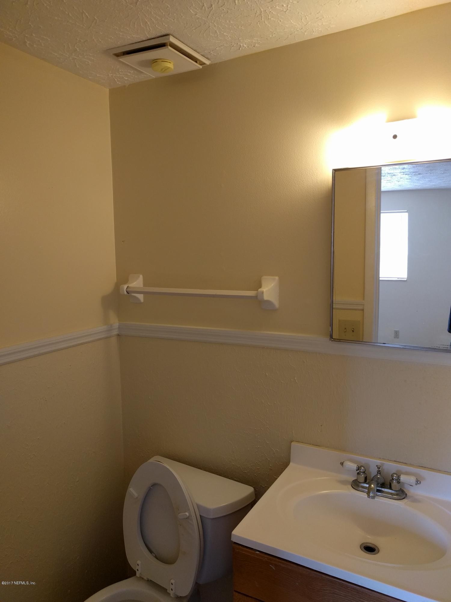 4339 Flintshire Road Jacksonville, FL 32208 - Photo 10 of 15 a bathroom with a sink a toilet and a mirror