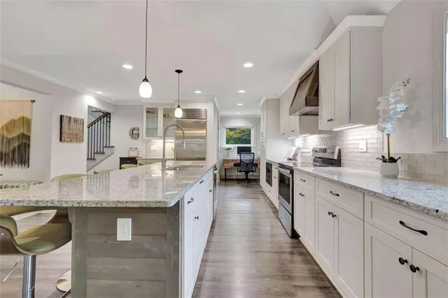 a kitchen with stainless steel appliances granite countertop a sink counter space cabinets and a large window
