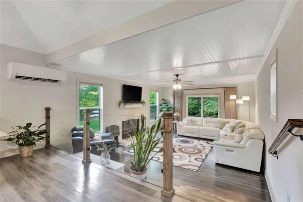 a living room with furniture flat screen tv and a large window