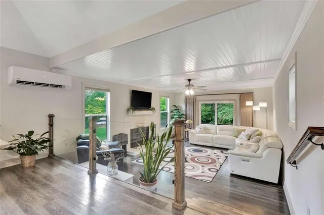 a living room with furniture flat screen tv and a large window