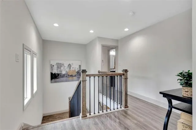 a view of a hallway with workspace and wooden floor