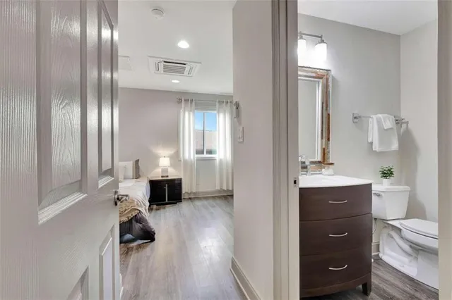 a bathroom with a toilet a sink a mirror and a shower