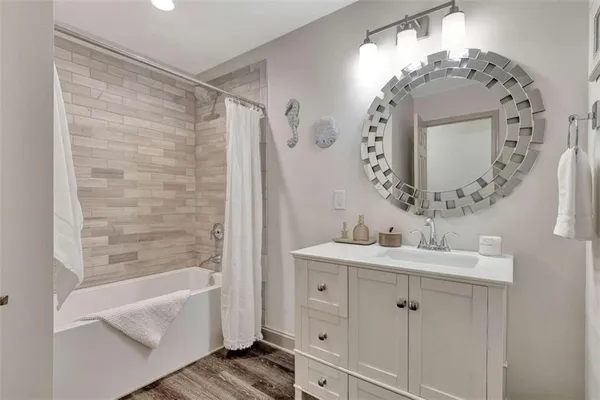 a bathroom with a double vanity sink mirror and bathtub