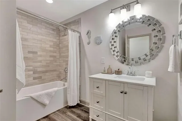 a bathroom with a double vanity sink mirror and bathtub