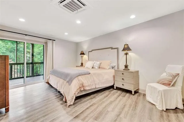a large bedroom with a bed and wooden floor