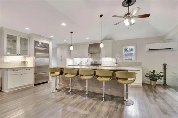 a dining room with stainless steel appliances kitchen island granite countertop furniture and a wooden floor