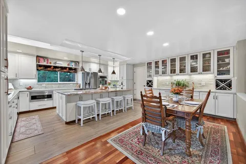 a kitchen with stainless steel appliances granite countertop a stove and a wooden floors