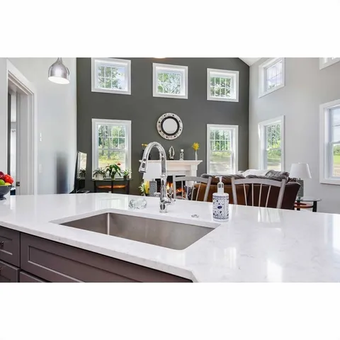a large white kitchen with a large window and stainless steel appliances