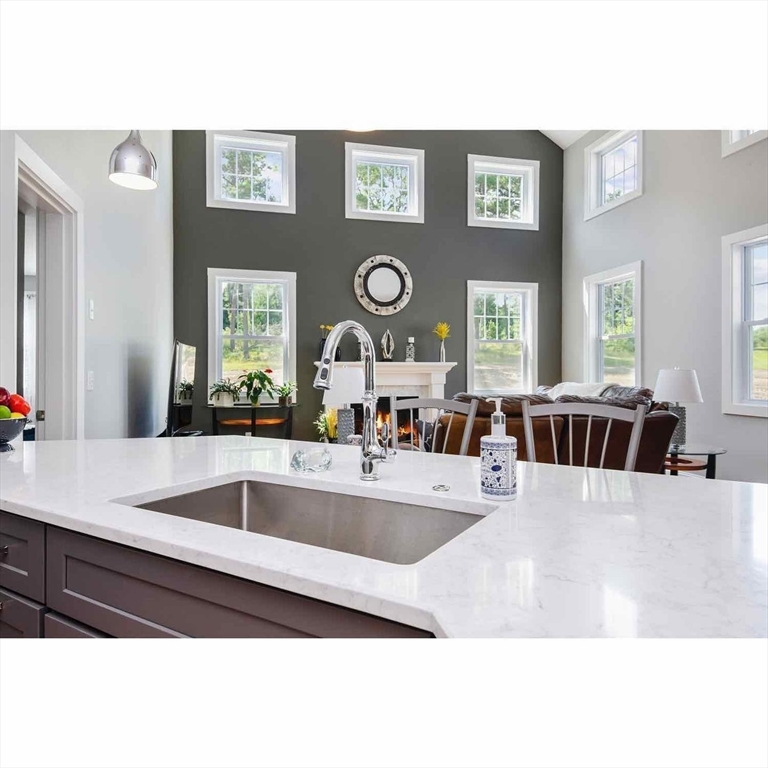 a large white kitchen with a large window and stainless steel appliances