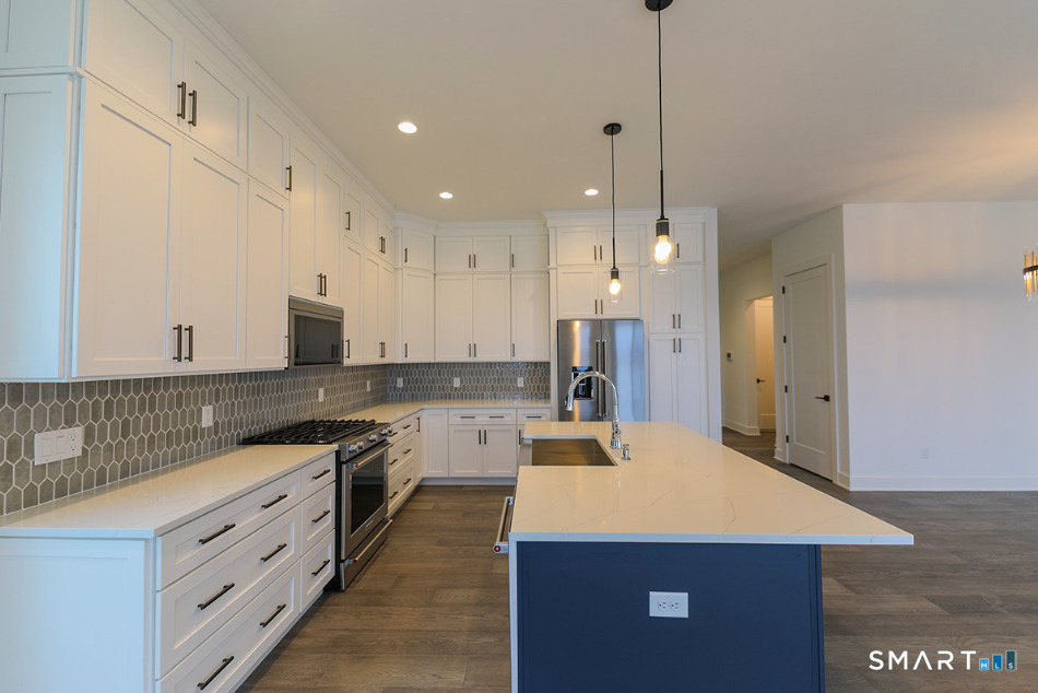 35 Lookout Ridge, Unit 35 Danbury, CT 06810 - Photo 17 of 38 a large kitchen with kitchen island a sink a stove a refrigerator and white cabinets
