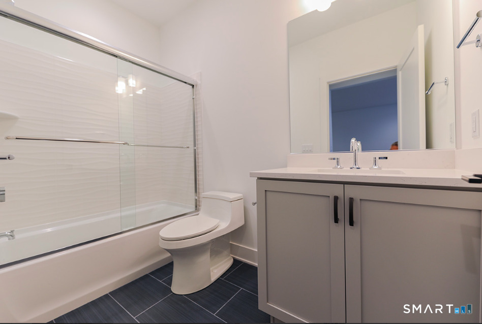 35 Lookout Ridge, Unit 35 Danbury, CT 06810 - Photo 34 of 38 a bathroom with a sink a toilet a mirror and shower