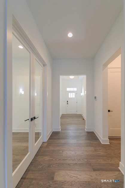 35 Lookout Ridge, Unit 35 Danbury, CT 06810 - Photo 6 of 38 an empty room with wooden floor and mirror