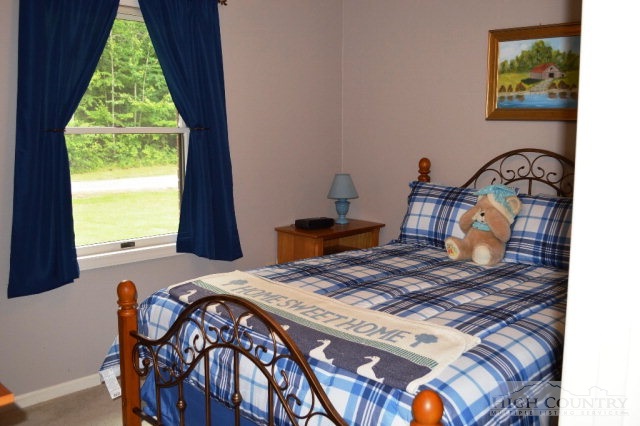 277 Pioneer Ridge Sparta, NC 28675 - Photo 24 of 36 a bed sitting in a bedroom next to a window