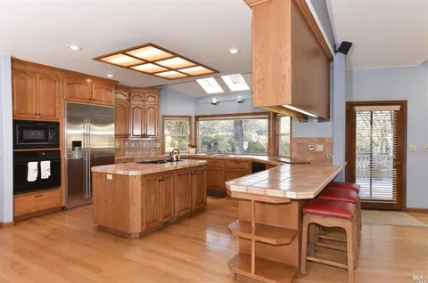 a kitchen with stainless steel appliances granite countertop a stove and a wooden floors