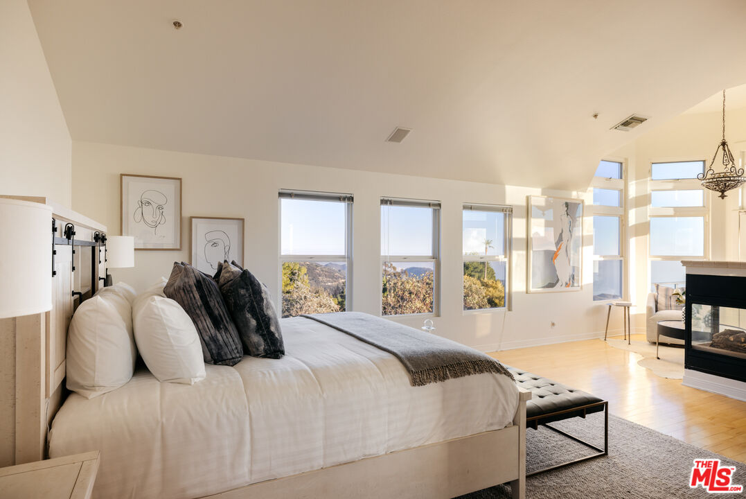 401 Moonrise Drive Malibu, CA 90265 - Photo 21 of 47 a spacious bedroom with a large bed and a large window