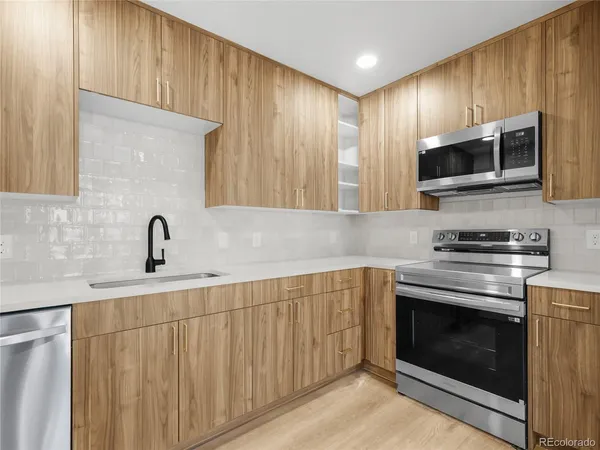 a kitchen with stainless steel appliances wooden cabinets and a stove top oven