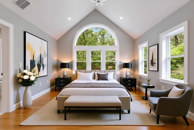 a bedroom with a bed couches and a large window