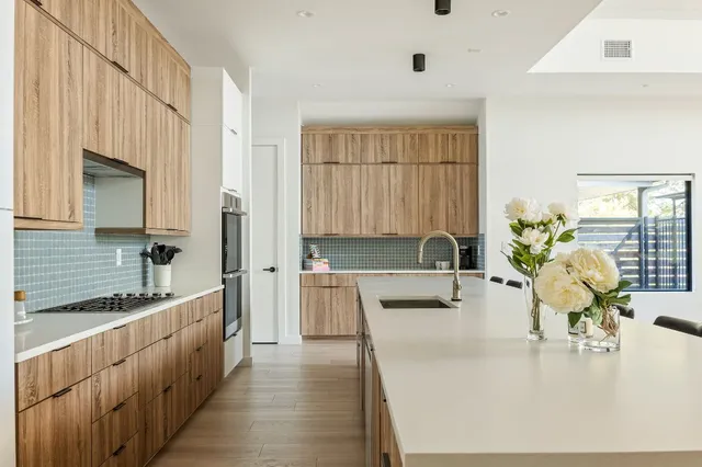 a large white kitchen with wooden floor