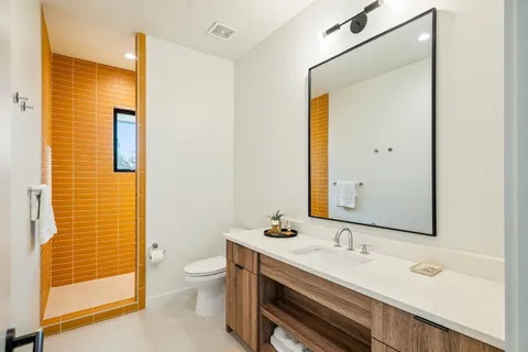 a bathroom with a granite countertop sink toilet and shower