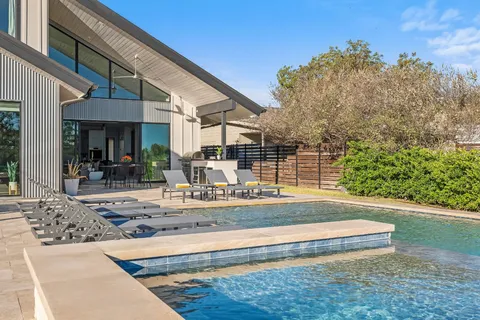 a view of a house with backyard and sitting area