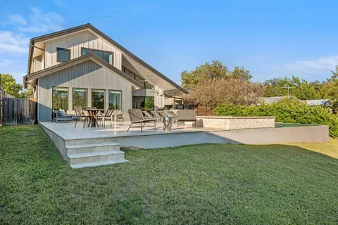 a front view of a house with swimming pool having outdoor seating