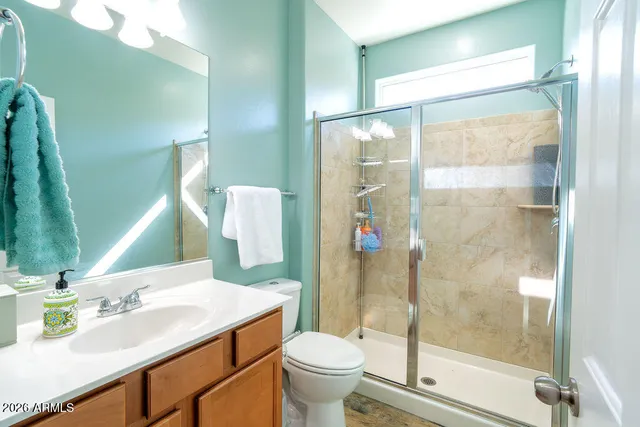 a bathroom with a sink vanity mirror and toilet