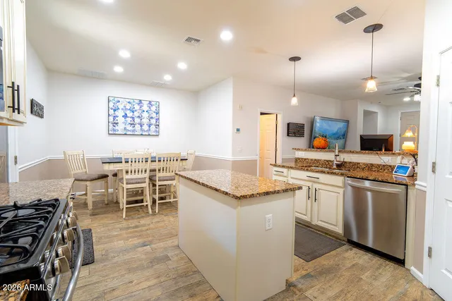 a kitchen with stainless steel appliances granite countertop a stove top oven a sink a counter top space and cabinets