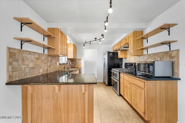 a kitchen with stainless steel appliances granite countertop a sink and a stove