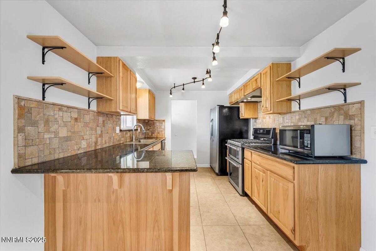 1275 Bolivia Way Gardnerville, NV 89460 - Photo 15 of 59 a kitchen with stainless steel appliances granite countertop a sink and cabinets