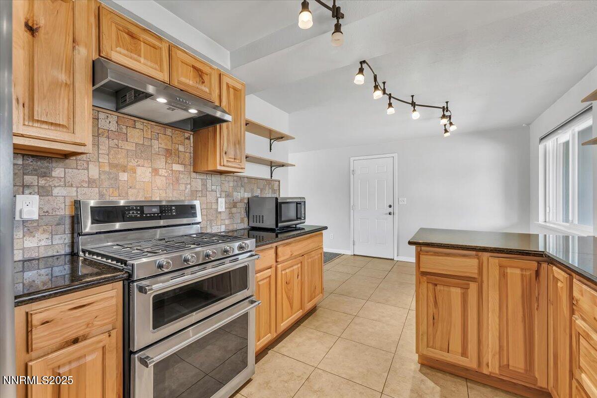 1275 Bolivia Way Gardnerville, NV 89460 - Photo 17 of 59 a kitchen with stainless steel appliances granite countertop a stove and a refrigerator