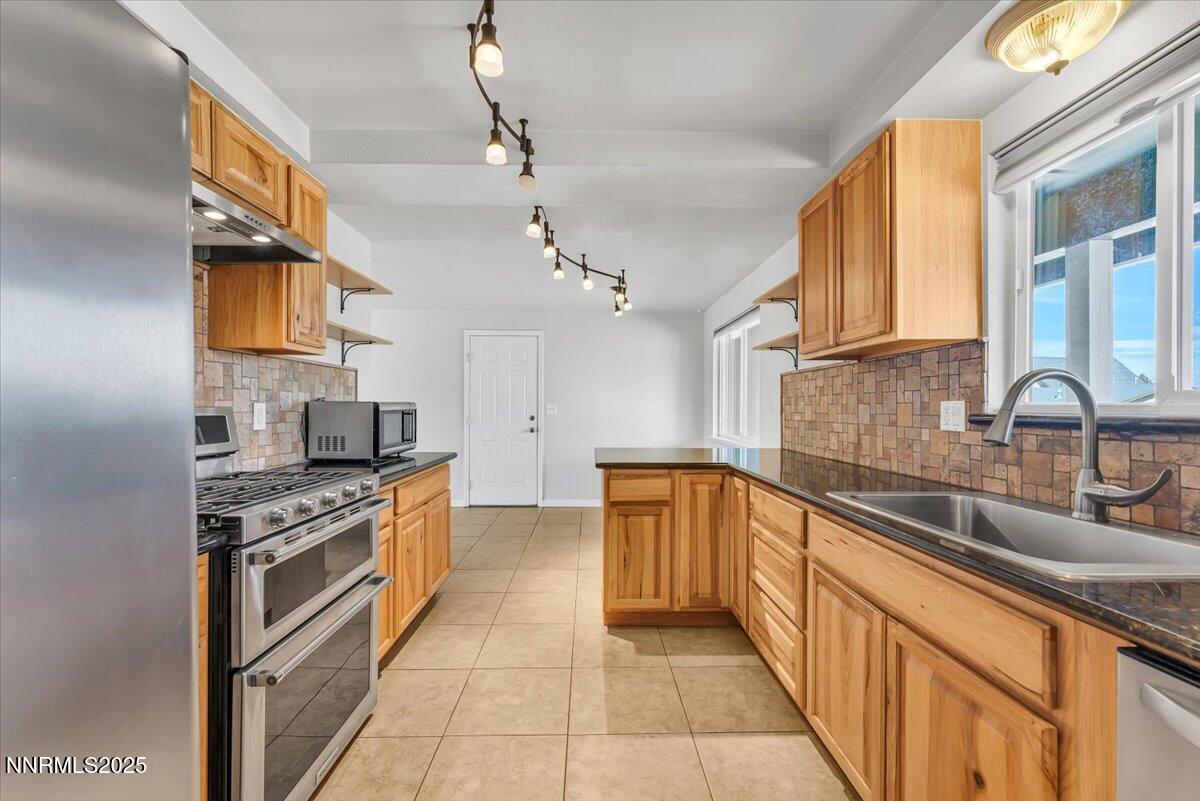 1275 Bolivia Way Gardnerville, NV 89460 - Photo 18 of 59 a kitchen with stainless steel appliances granite countertop a sink and a stove