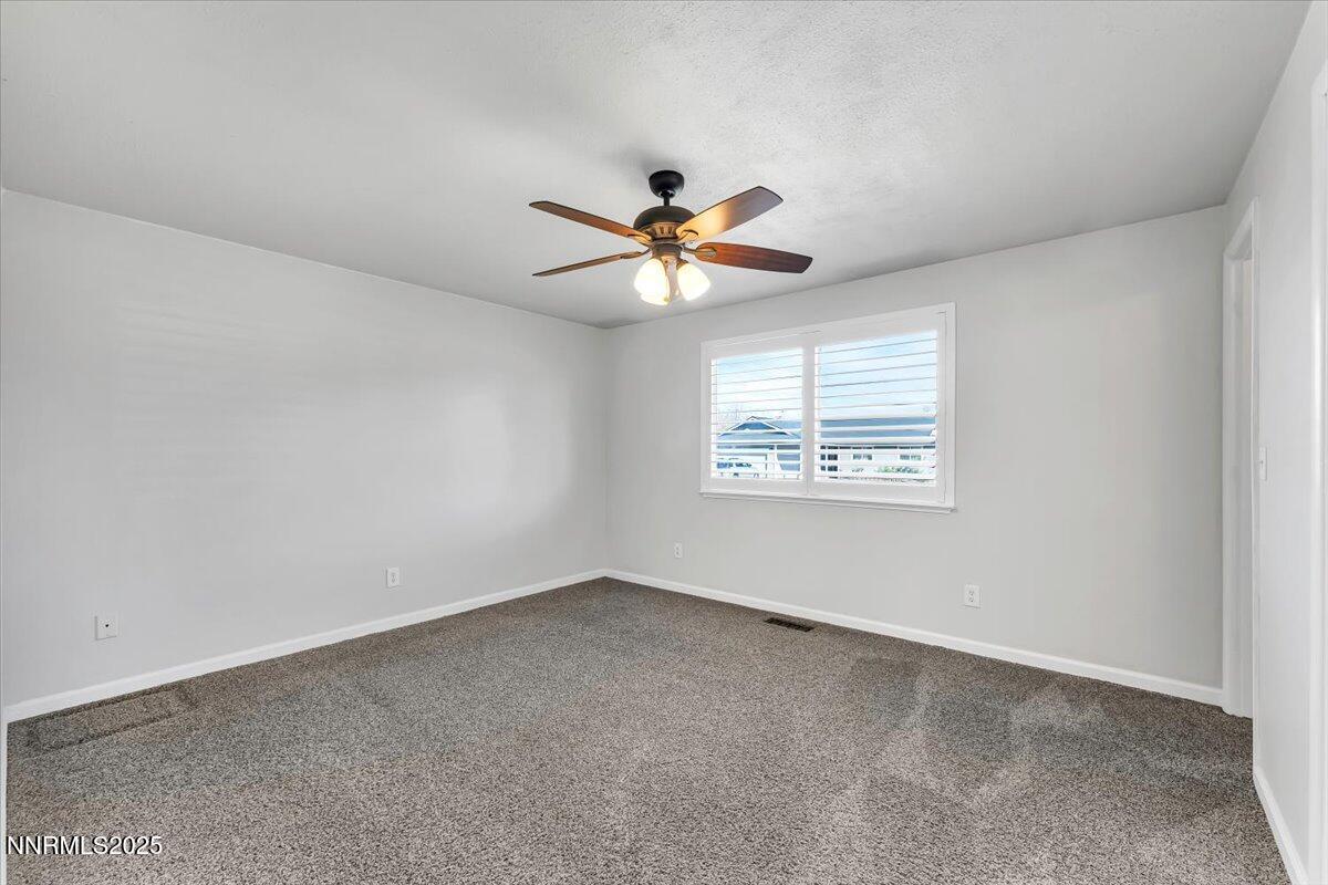 1275 Bolivia Way Gardnerville, NV 89460 - Photo 21 of 59 an empty room with chandelier fan and windows