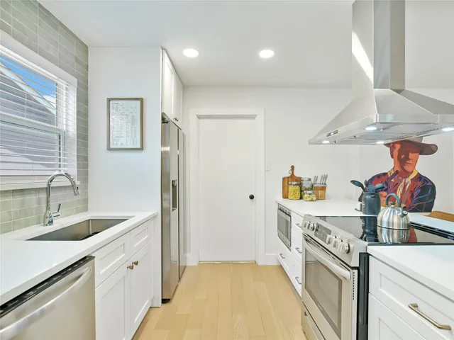 a kitchen with a sink a stove and a refrigerator