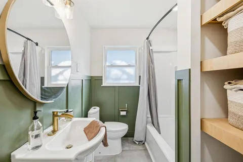 a bathroom with a toilet sink and mirror