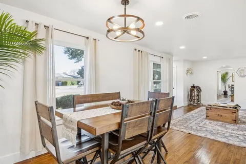 a dining room with furniture a chandelier and wooden floor