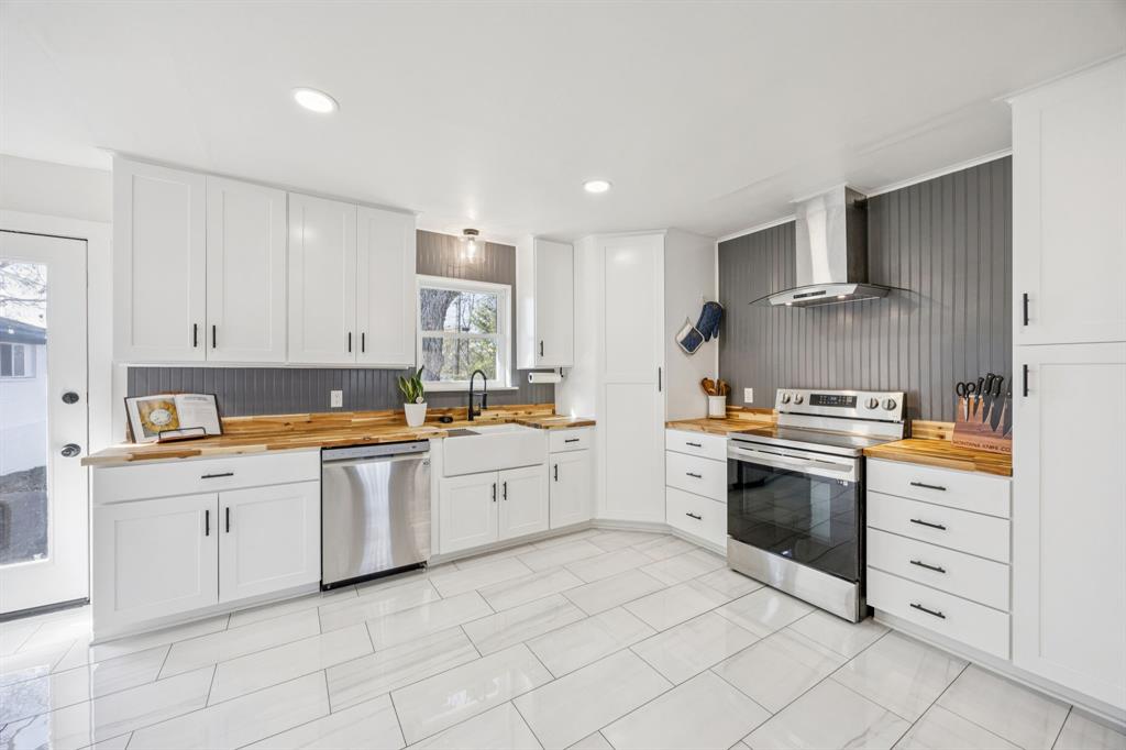 207 Joe White Street Rockwall, TX 75087 - Photo 23 of 27 a kitchen with granite countertop white cabinets and white stainless steel appliances