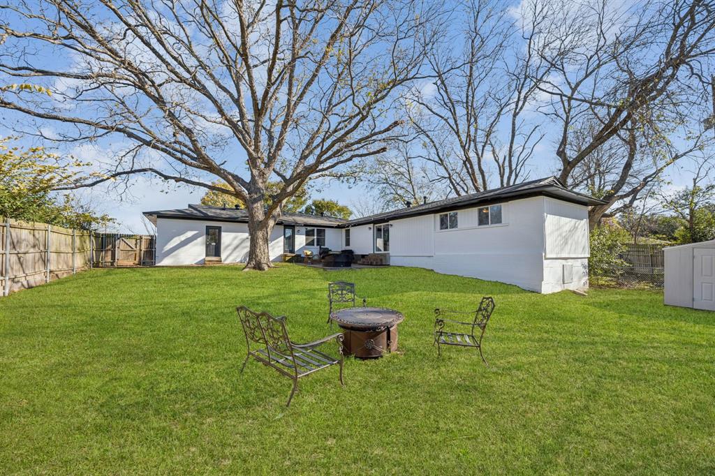207 Joe White Street Rockwall, TX 75087 - Photo 24 of 27 a view of a backyard with table and chairs and large tree