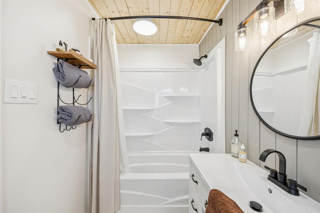 207 Joe White Street Rockwall, TX 75087 - Photo 8 of 27 a bathroom with a sink and mirror with bathtub